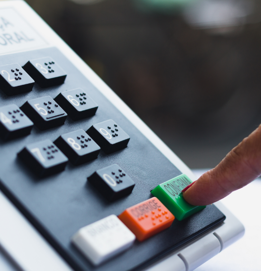 Die Finger einer älteren Person wählen auf einem Telefon mit Braille-Zeichen.